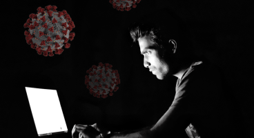 person on computer, corona virus in the background
