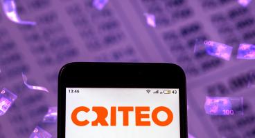 CRITEO Logo shown on the screen of a phone, numbers and falling 100€ bills in the background